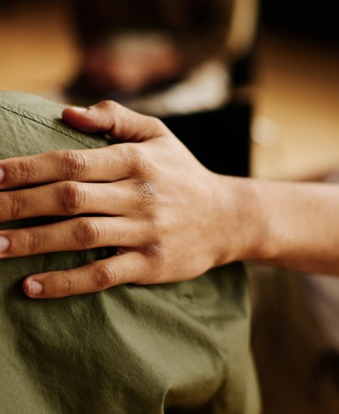 Hand of young supportive man consoling his friend