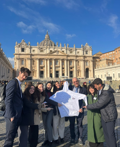 Middle Meets in the Vatican–Holding a Sweatshirt Signed by Pope Francis and All Participants. | Credit: Scholas Occurrentes