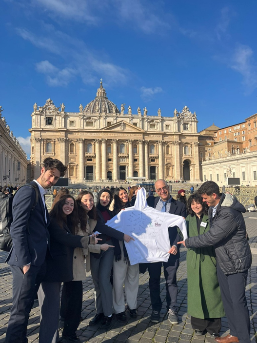 Middle Meets in the Vatican–Holding a Sweatshirt Signed by Pope Francis and All Participants. | Credit: Scholas Occurrentes